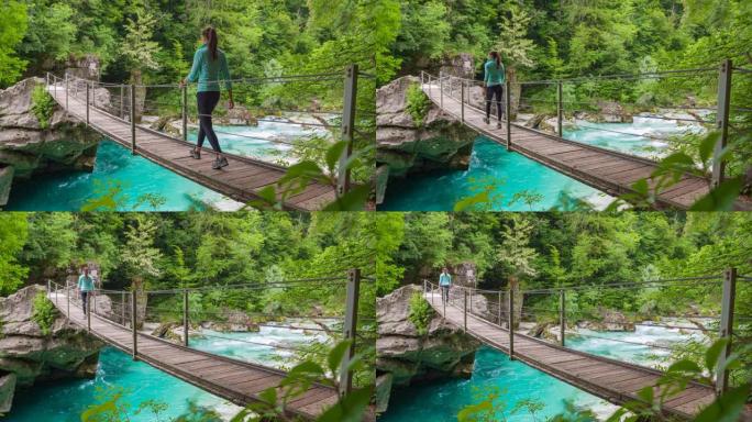 女游客徒步穿越山溪峡谷上的一座木桥