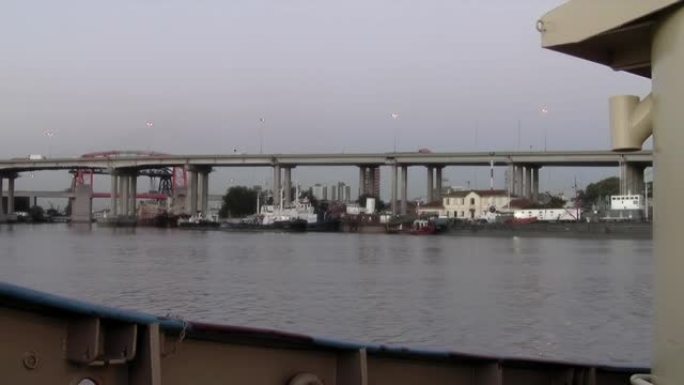 从黎明时离开港口的拖船上看到，阿根廷布宜诺斯艾利斯的拉博卡区和南部公路的旧运输桥。