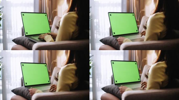 女人在家工作时看着绿屏笔记本电脑
