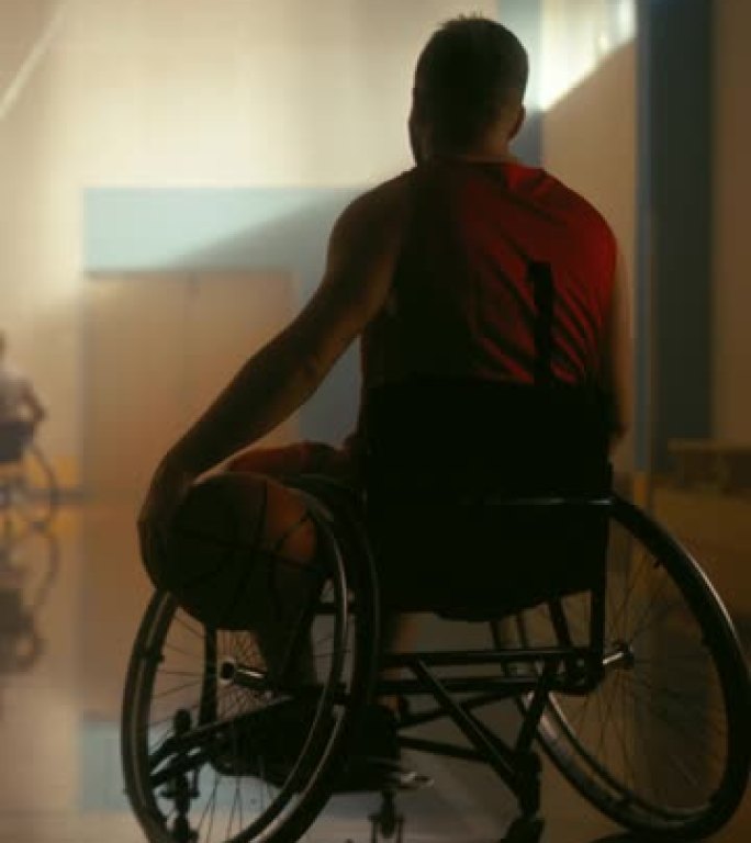 垂直视频。轮椅篮球比赛: 穿着红色衬衫的球员持球等待轮到他。运动员观看他的团队比赛。确定在运动中表现
