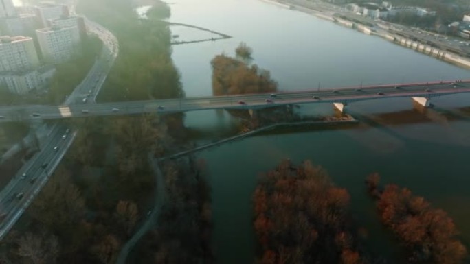 汽车在雄伟的桥上沿着维斯拉河移动。波兰华沙秋季日出的田园诗般的空中天桥拍摄