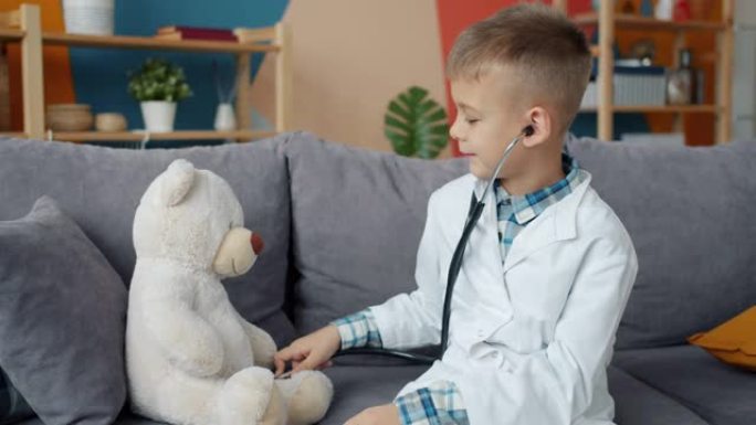 穿着白色医疗礼服的快乐孩子在家用听诊器检查填充熊