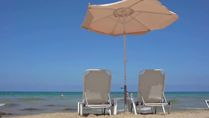 站在海滩上的两个日光浴躺椅