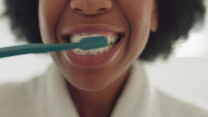 黑人妇女，在酒店，房屋或家庭内部的浴室刷牙和牙齿美容。面部放大牙刷、牙膏和非洲人清洁口腔在健康保健早