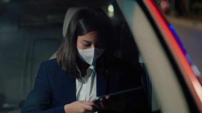 女人晚上通勤时戴医用口罩。