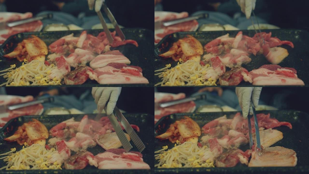 亚洲人在烤架上翻转美味的韩国烧烤的特写镜头。