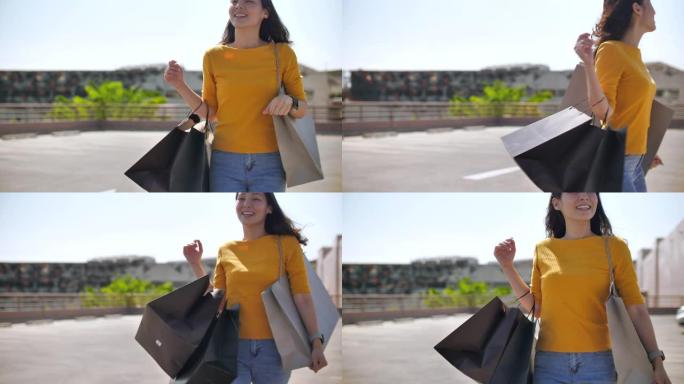 年轻的亚洲妇女在购物商店里背着购物袋