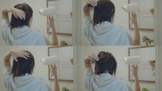 女人用吹风机吹干头发。