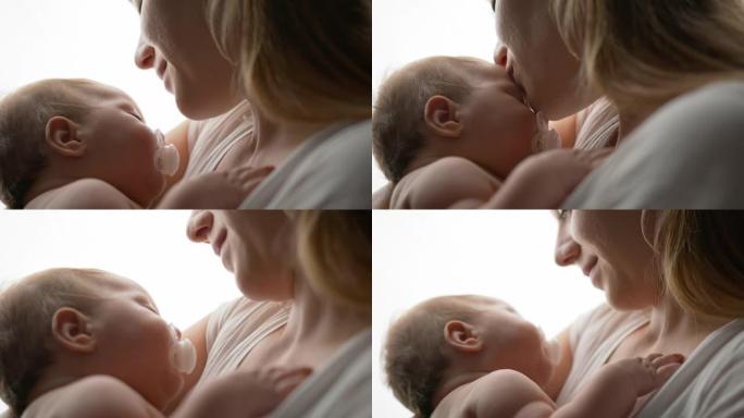 SLO MO深情的年轻母亲亲吻她熟睡的婴儿男孩