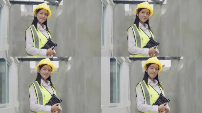 戴着安全帽站在建筑工地的亚洲女建筑师
