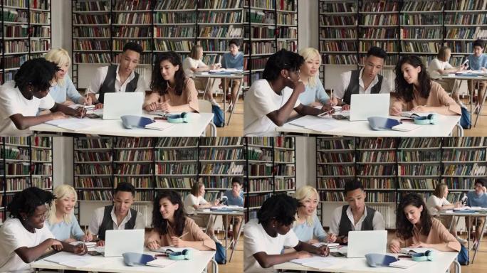 一群学生坐在笔记本电脑上写论文的图书馆