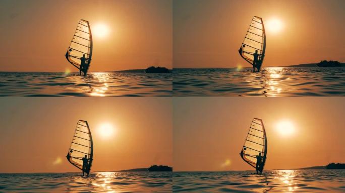 风帆冲浪者在夕阳下渡海
