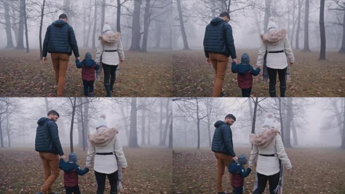 父母与儿子在雾笼罩的公园里共度时光