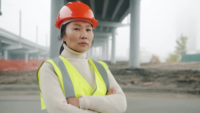 女建筑工程师亚洲女士站在建筑区域双臂交叉的肖像