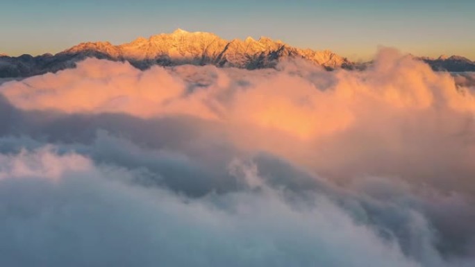 日出时，雪山前滚滚的云海极为壮观