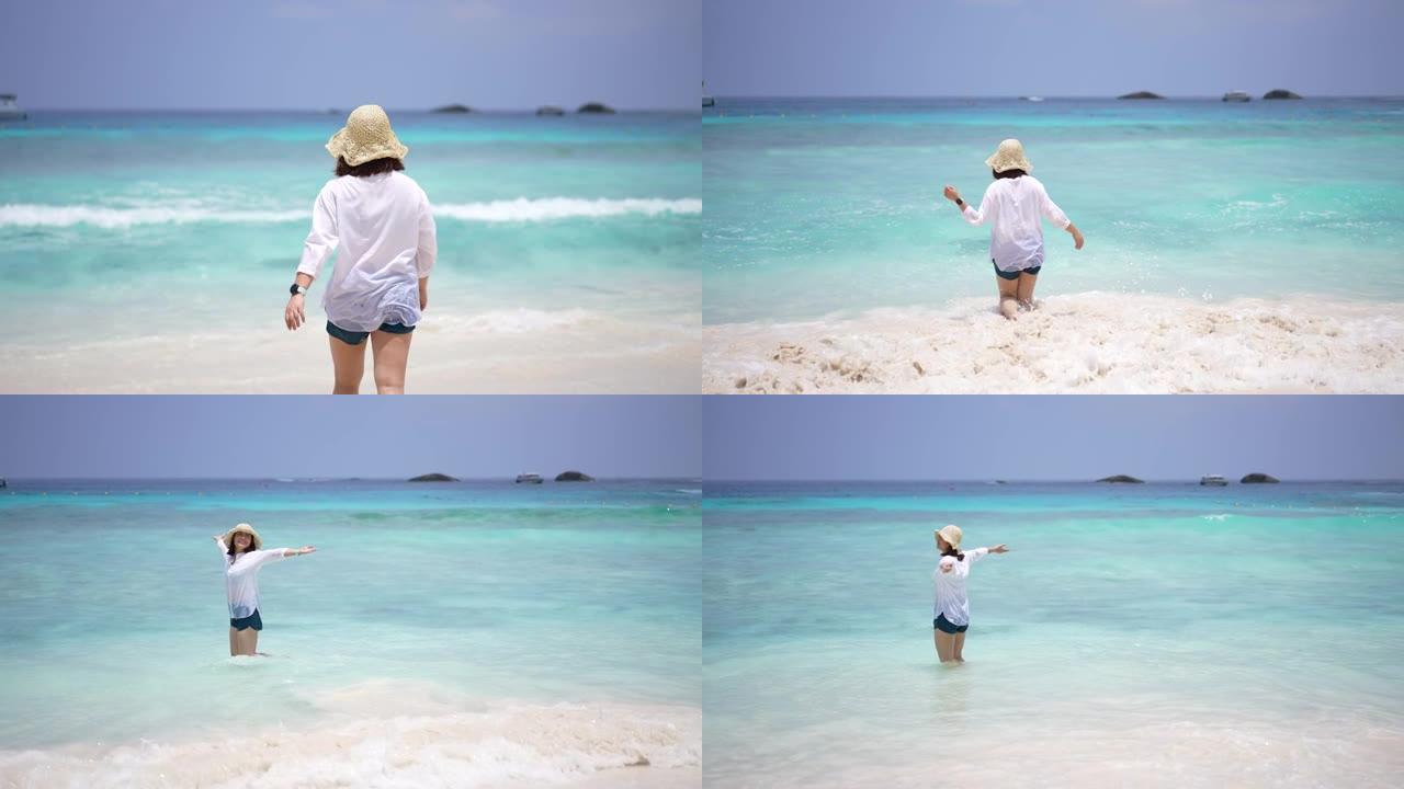 在泰国西米兰岛，蓝色的海和白色的沙滩上享受快乐的女人