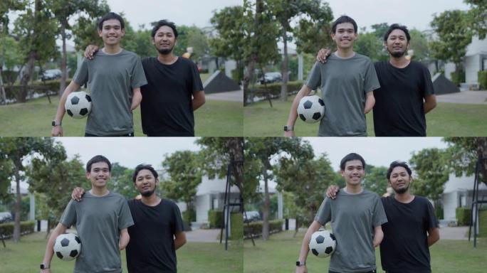 两个快乐的年轻人拿着足球的肖像。