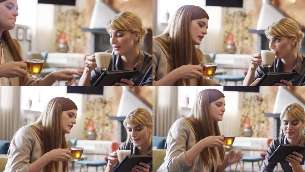 两名迷人的女商人坐在咖啡馆里使用数字平板电脑的4k视频片段