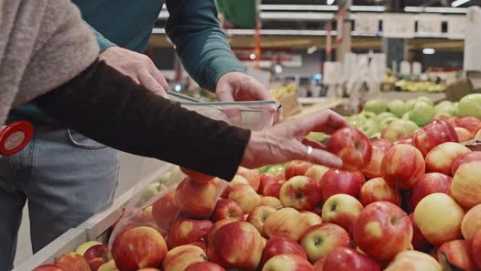 客户将苹果放在可重复使用的农产品袋中