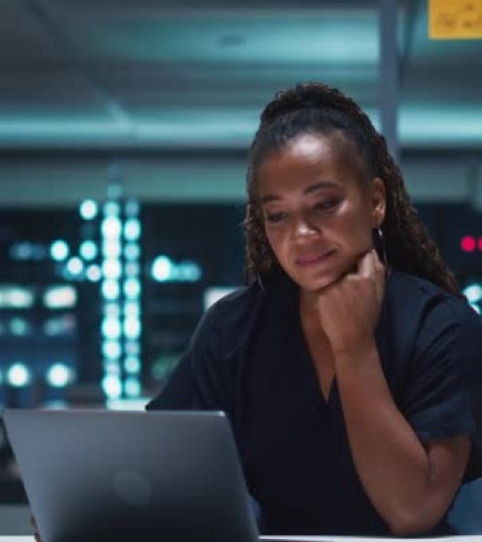 垂直屏幕: 成功的黑人女商人在深夜在办公室的笔记本电脑上工作。管理数字电子商务项目，财务分析的女执行