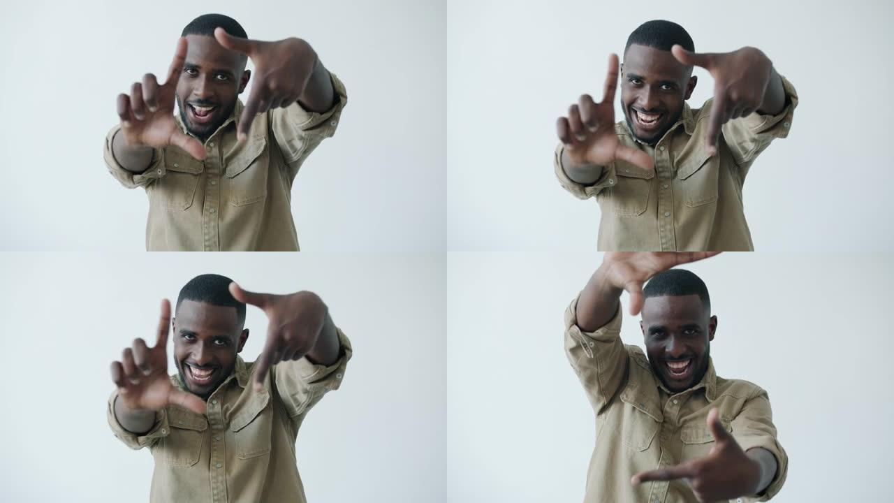 微笑的非洲裔美国男子做框架手势并看着相机的慢动作