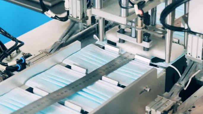 输送机正在将松紧带连接到新的医用口罩上