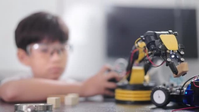一个小学生在笔记本电脑上编程机器人