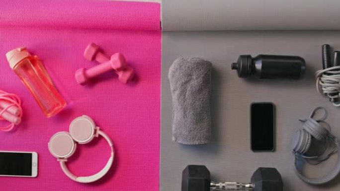 粉色和灰色瑜伽垫，上面有健身器材。耳机，健身器材，水瓶，跳绳，哑铃放在复制空间上。专注于健身和健康的