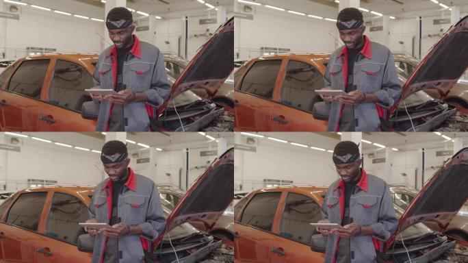非裔美国机械师在汽车维修车库中使用平板电脑