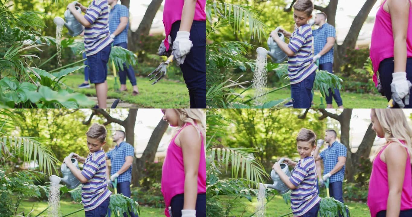 微笑的高加索兄弟姐妹与父母一起园艺，微笑和浇水植物