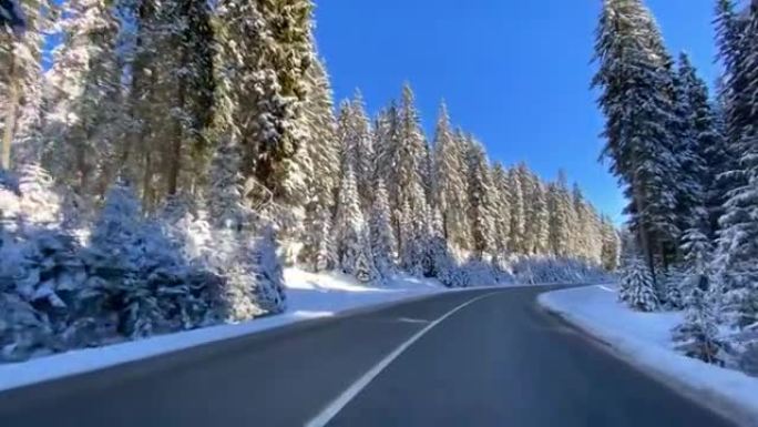 穿越白色森林的雪乡公路上的驾驶视点