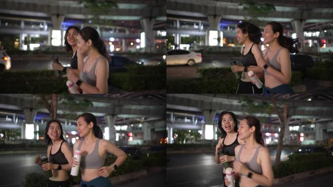两个运动女人晚上一起跑步锻炼