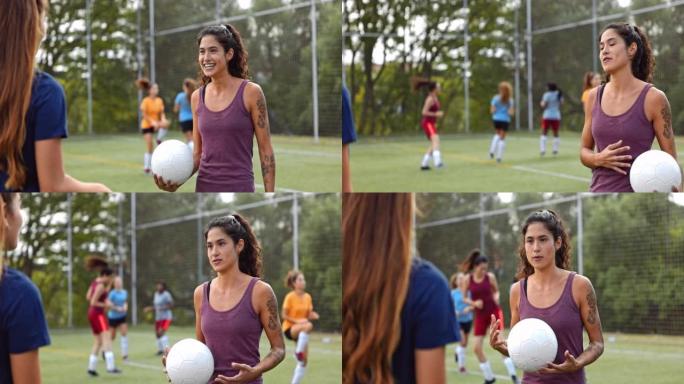 女足球运动员在练习中与队友交谈
