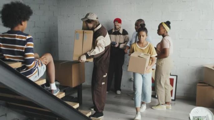 非裔美国人家庭的Slowmo从搬运工那里接收箱子