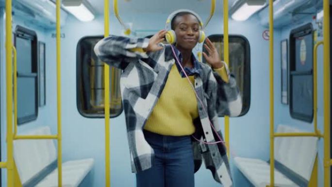 年轻时尚的黑人妇女戴上耳机，在电车上随着歌曲的节奏跳舞。充满活力的自信的年轻女性跟随节拍并在公共交通