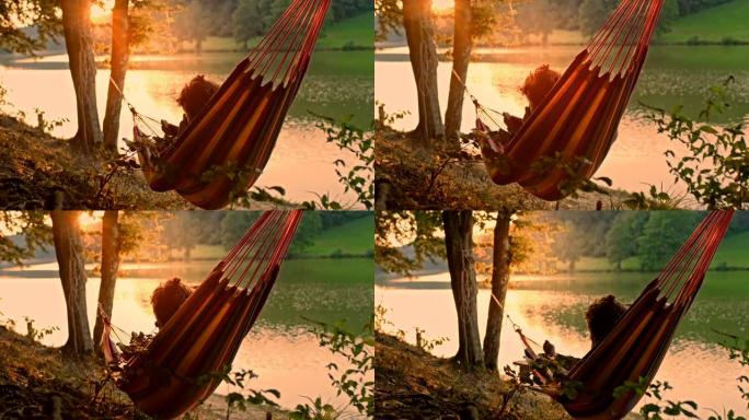 慢动作男子在日落时在湖边拍照