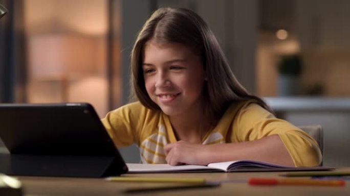 一个年轻女孩独自坐在家里并使用数字平板电脑进行虚拟课程的4k视频片段