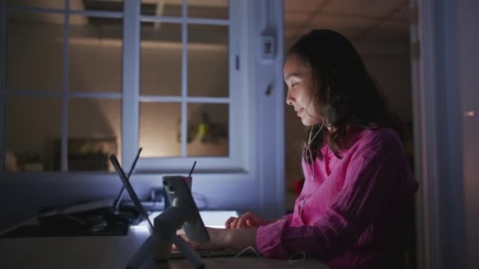 女人在家用笔记本电脑打字直到深夜