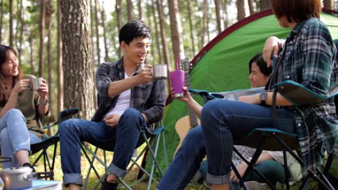 一群朋友在松树露营地的户外露营中，在帐篷前享受