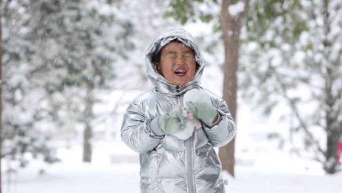 蹒跚学步的小男孩在冬天玩雪