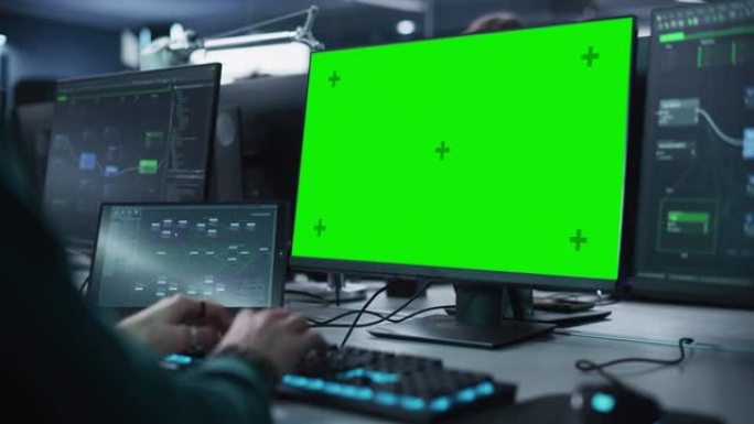 关闭在具有绿屏模拟显示的台式计算机上工作的软件开发人员。专家在键盘上打字，编码和实施新技术功能，在代
