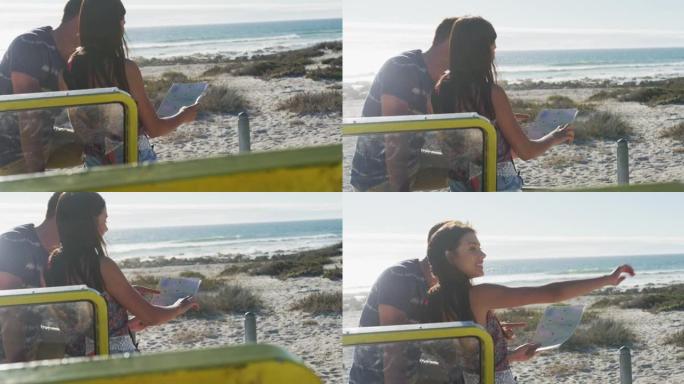 白人夫妇站在海边的海滩越野车旁阅读地图