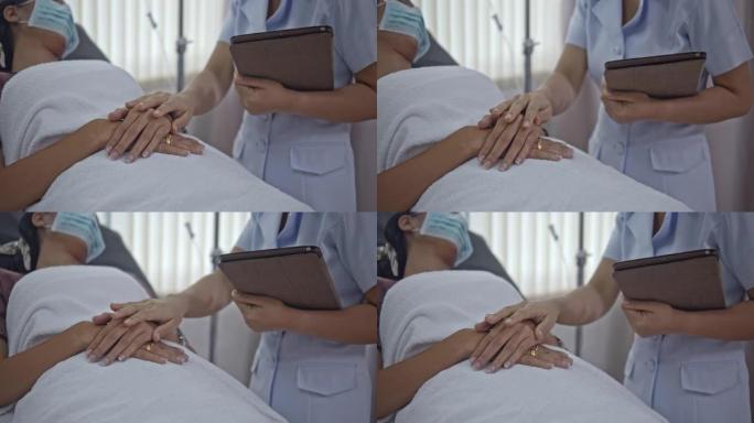 防护面罩中的SLO MO护士在医院病床上触摸病人的手希望，特写