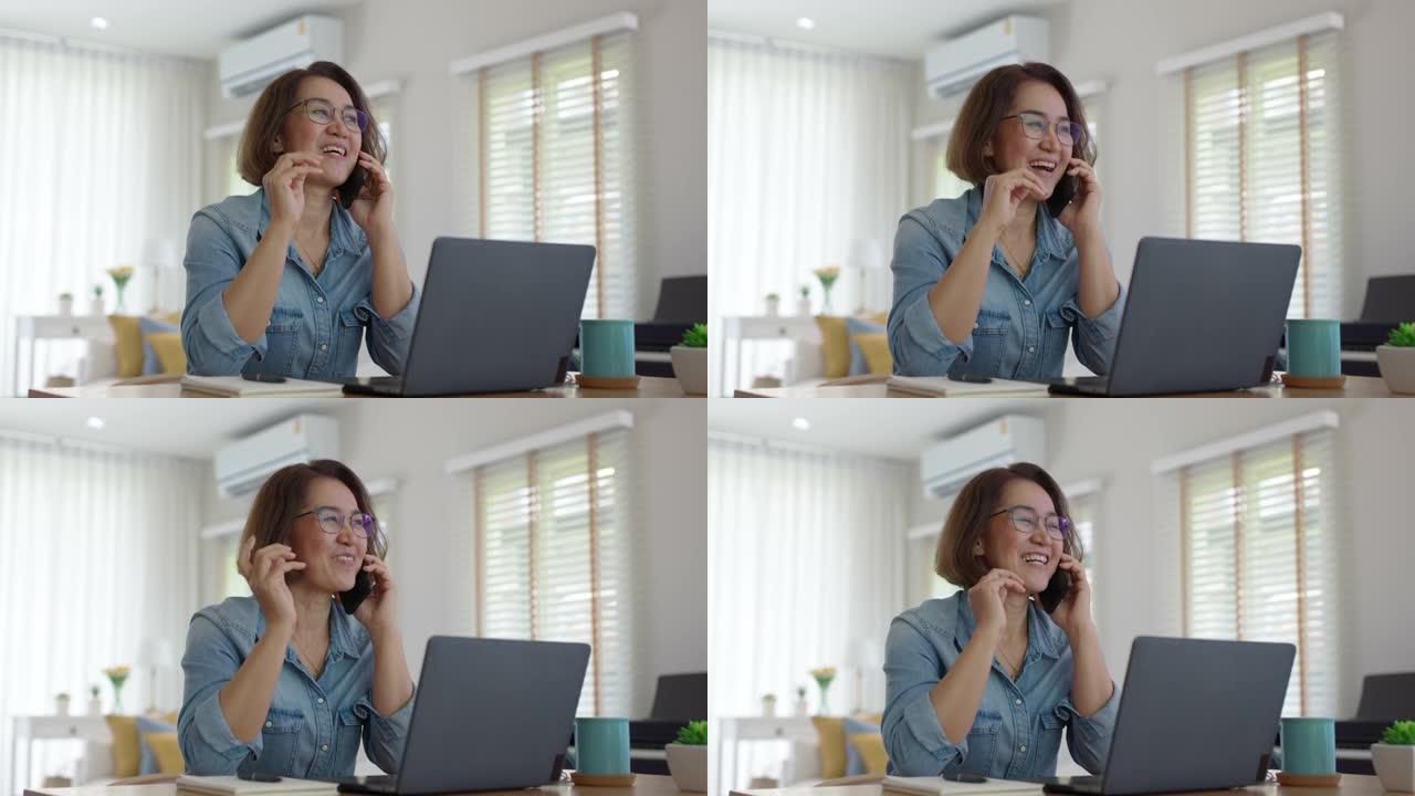 亚洲成熟成年女性在手机上通话在家快乐工作。
