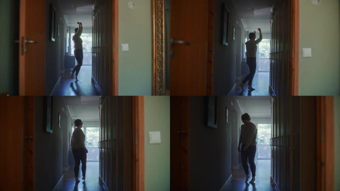 戴着耳机的快乐年轻女子在公寓走廊跳舞。放大多莉的欢快女孩心情愉快地听音乐的镜头。