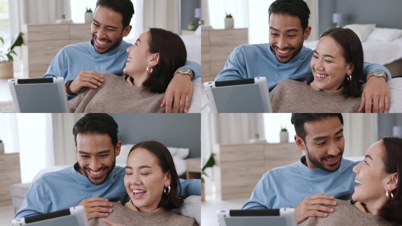 亚洲夫妇在平板电脑上播放电影，在线观看订阅服务上的有趣视频，并在家里的沙发上谈论社交媒体通知。快乐，