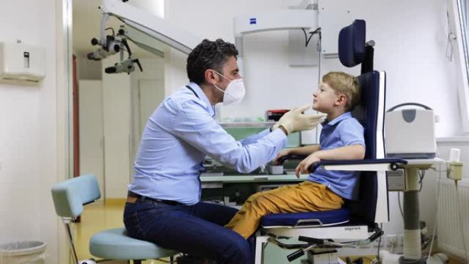 儿科医生在临床检查男孩的喉咙