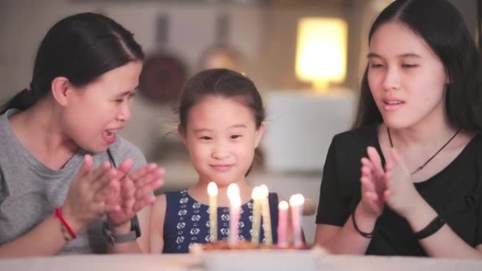 亚洲家庭有小女孩在家吹蜡烛生日蛋糕