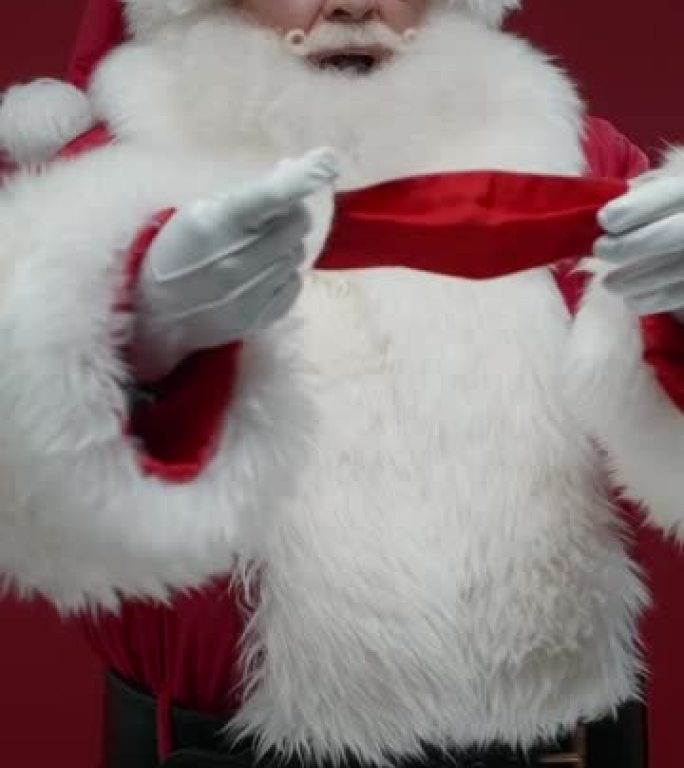 红色背景上的圣诞老人的垂直视频，他记得他需要戴上红色的防护面罩