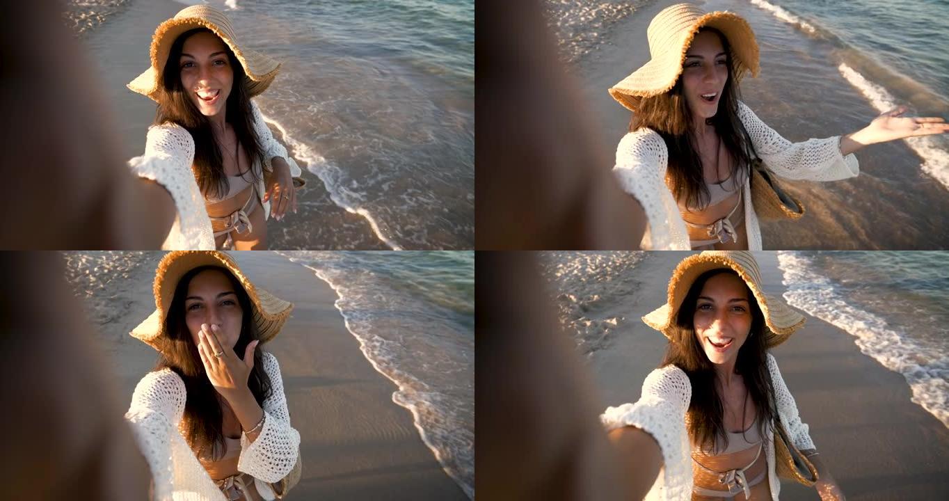 一个快乐的无忧无虑的年轻女性游客戴着草帽，在度假旅行期间，在阳光明媚的日子里，在沙漠近海海边，通过电